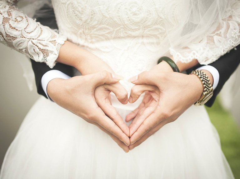 ein Hochzeitspaar formt ein Herz aus den Händen